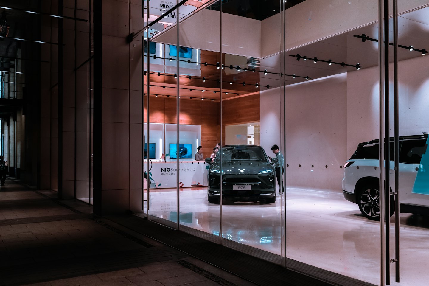 Kunde begutachtet einen dunkelgrauen Elektro-SUV in einem Autohaus.